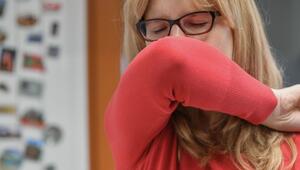 Eine Frau hustet in ihre Armbeuge