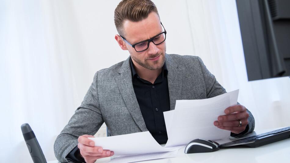 Ein Mann sieht im Büro in Unterlagen