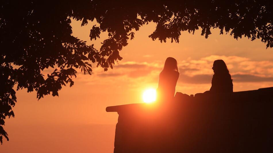 Zwei Frauen unterhalten sich bei Sonnenuntergang