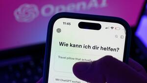 Smartphone mit dem KI-Chatbot ChatGPT vor dem Logo von OpenAI