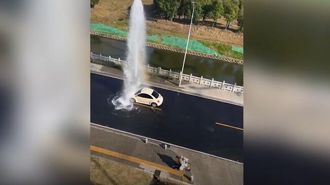 Auto fährt in Wasserfontäne