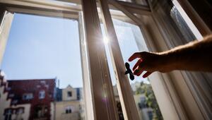 Eine Person öffnet in einer Berliner Wohnung ein Fenster