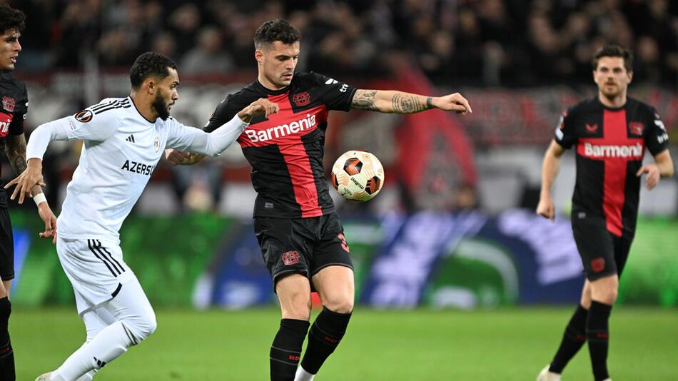 Bayer Leverkusens Granit Xhaka im Zweikampf mit Agdams Juninho