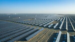 Großes Solarkraftwerk mit unzähligen Solarpanelen, die in Reihen auf einer kargen, leicht ...