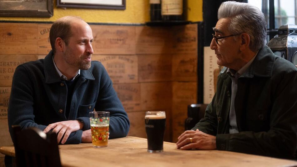 "Urlaub wider Willen mit Eugene Levy": Prinz William und Eugene Levy unterhalten sich in einem Pub.