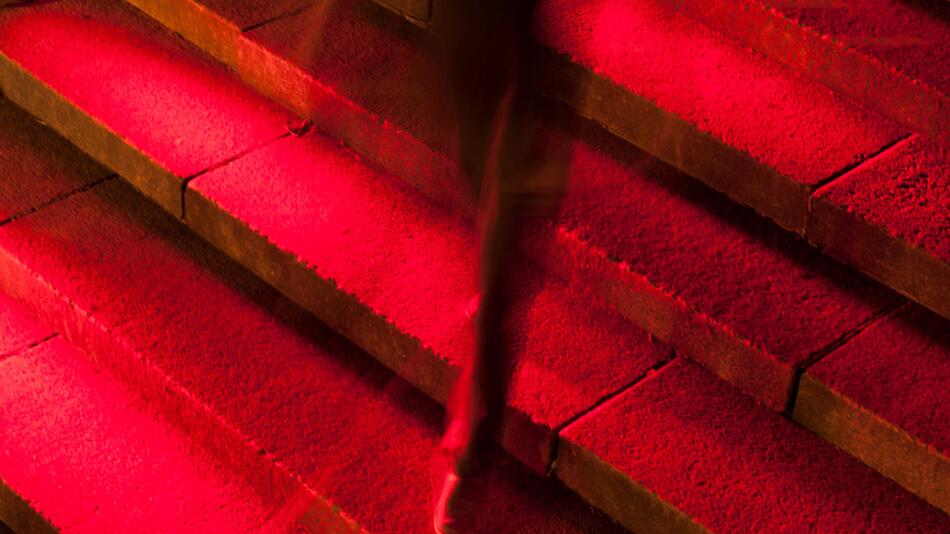 Männerbein in Anzug auf roter Treppe