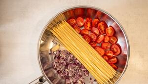 Spaghetti, Tomaten und Zwiebeln in einer Pfanne