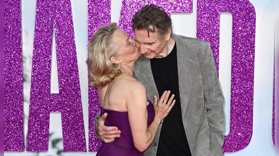 Pamela Anderson knutscht Liam Neeson auf die Wange - der scheint es sichtlich zu genießen.