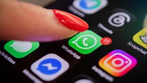 Eine Frau tippt auf einem Smartphone auf das WhatsApp-Symbol