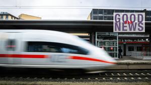 Ein ICE-Zug fährt mit hoher Geschwindigkeit an einem Bahnhof vorbei, im Hintergrund sind weitere ...