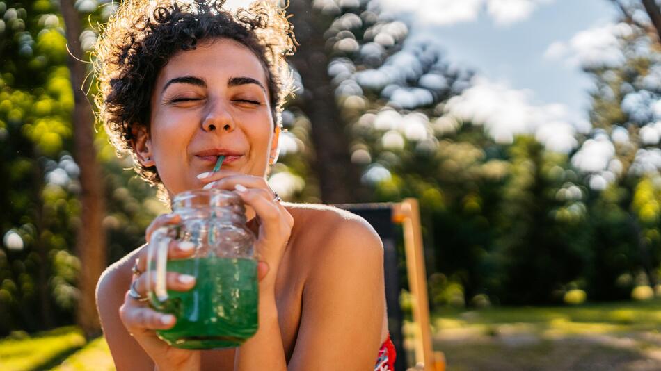 Frau trinkt im Sommer