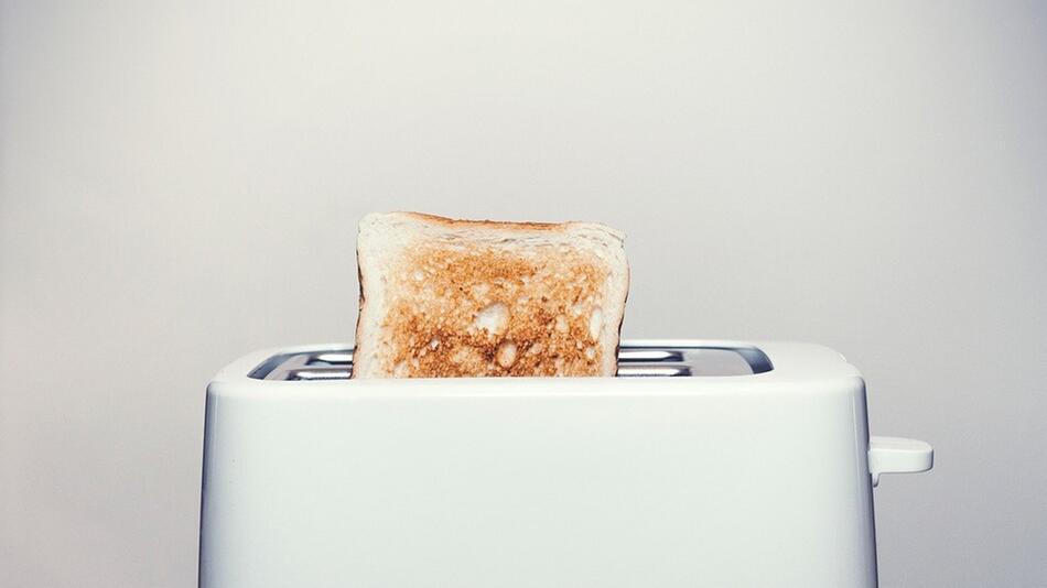 Schütte die Krümel aus, indem du den Toaster kopfüber hälst.