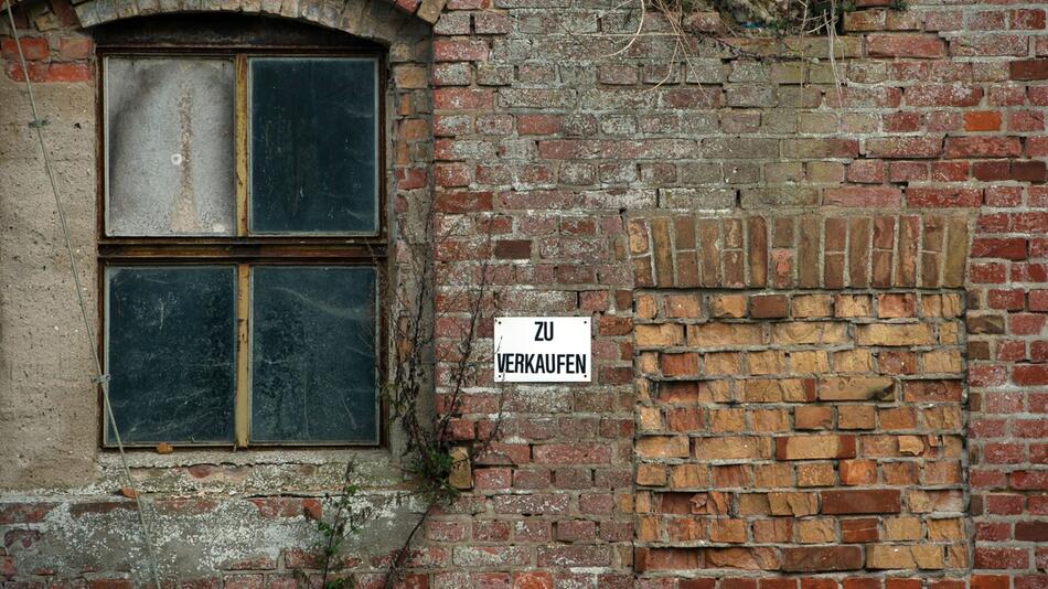 Ein Schild mit dem Schriftzug "Zu verkaufen" an einem Haus