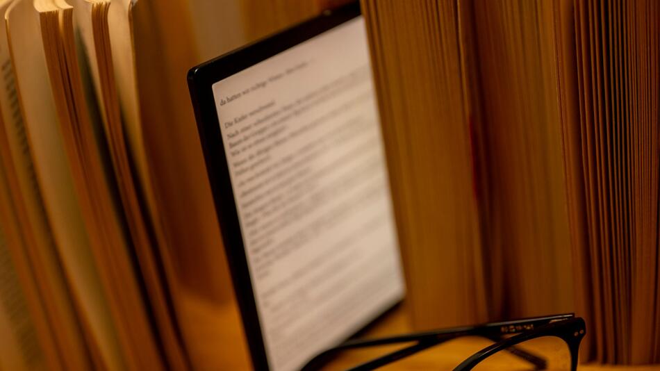 E-Book-Reader steht zwischen Büchern auf einem Tisch