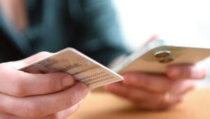 Eine Frau hält Personalausweis und Smartphone in den Händen