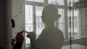 Eine Frau steht in einem Konferenzraum an einem Whiteboard