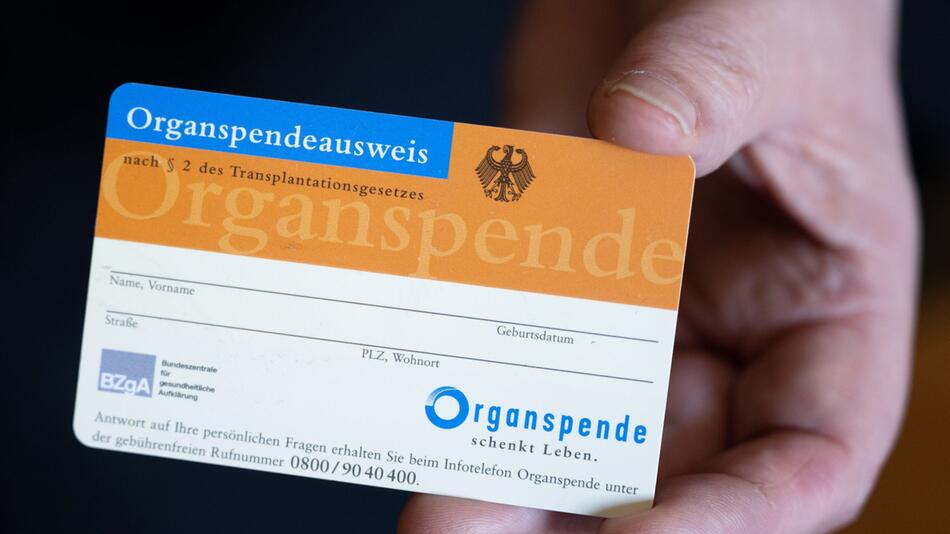 Frau hält einen Organspendeausweis in der Hand