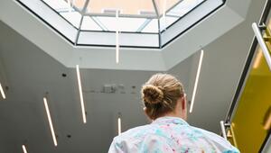 Frau steht im Foyer eines Unternehmens
