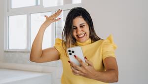 Frau schaut auf ihr Handy und freut sich 