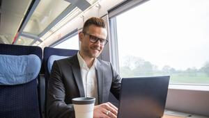 Ein mann arbeitet in einem Zug an einem Laptop