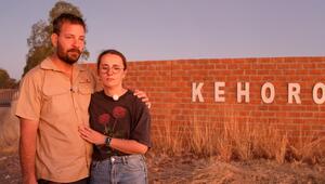 Gerald und Anna stehen ein letztes Mal vor dem Gelände ihrer Farm in Namibia.