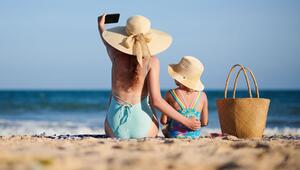 Mutter und Tochter machen ein Selfie am Strand