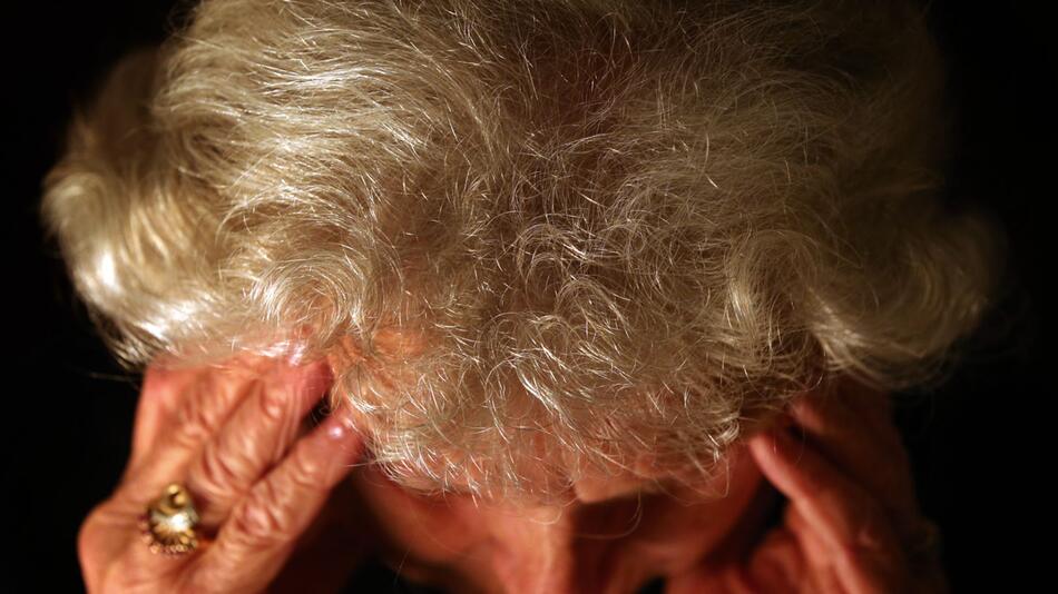 86-jährige Frau greift sich an den Kopf