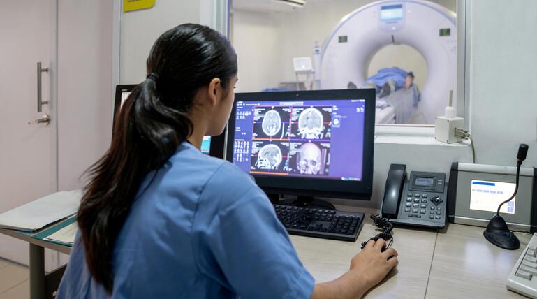Radiologin bei der Durchführung eines CT-Scans des Gehirns im Krankenhaus