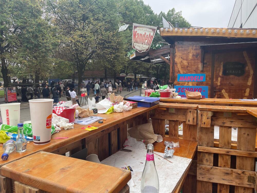 Forum - Müll im Vordergrund, im Hintergrund sehr viele Menschen auf dem Weg zur Wiesn.