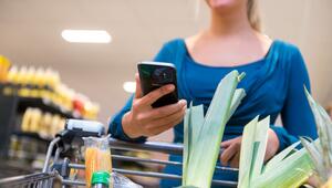 Eine Frau mit Smartphone im Supermarkt