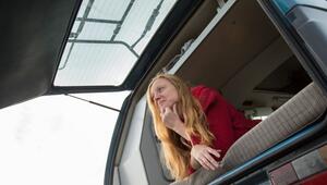 Eine Frau liegt auf dem Bett eines Campervans