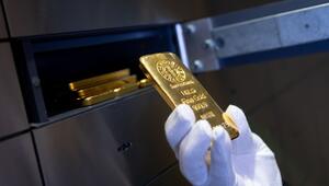 Mann legt einen Goldbarren in ein Schließfach eines Tresorraums