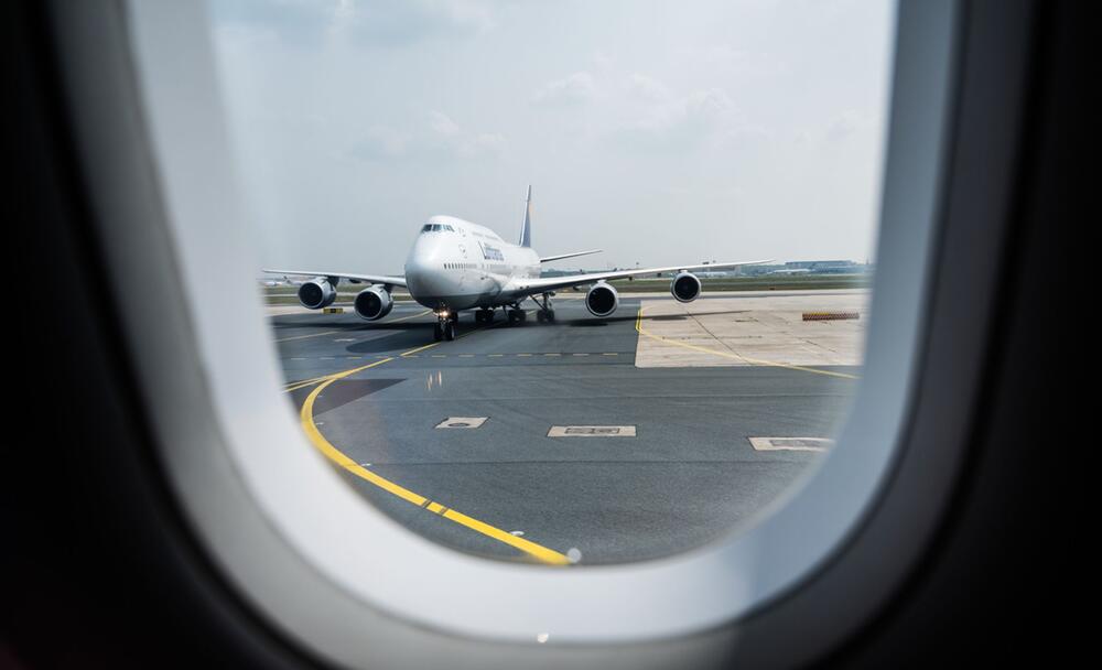 Blick aus einem Flugzeug auf die Rollbahn am Flughafen