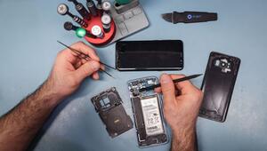 Techniker arbeitet an einem Smartphone mit defektem Display