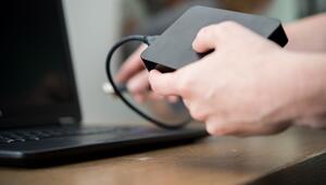 Eine Frau schliesst eine externe Festplatte an einem PC an