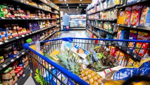 Ein gefüllter Einkaufswagen steht im Supermarkt