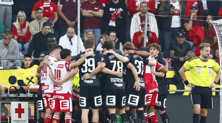 Die Spieler schirmten den Graz-Torwart für die weitere Behandlung ab
