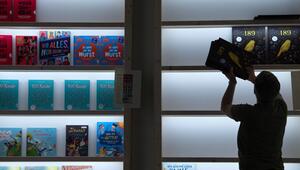 Frau räumt bei der Frankfurter Buchmesse Bücher in ein Regal
