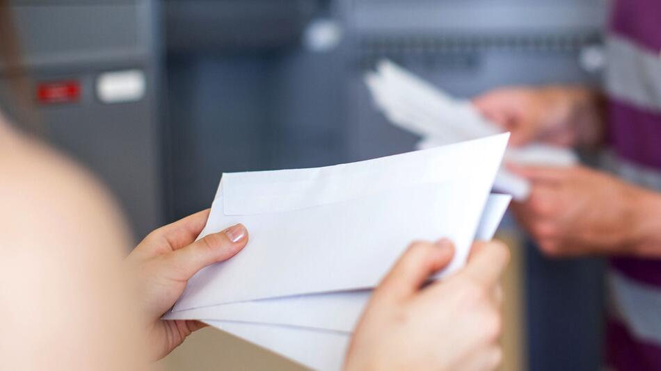 Ein Paar steht am Briefkasten