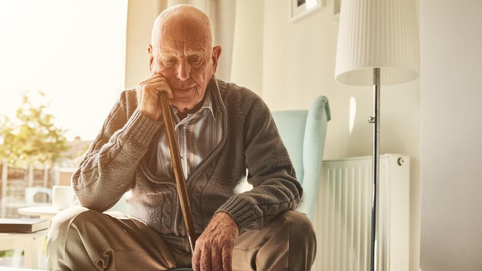 Alter Mann sitzt alleine zu Hause