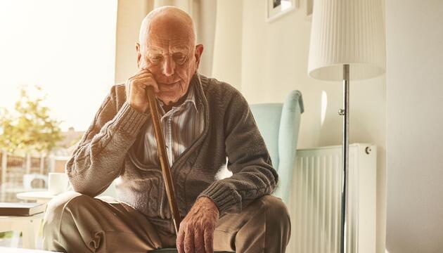 Alter Mann sitzt alleine zu Hause