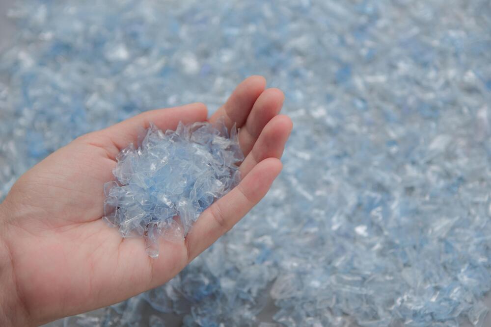 Hand mit kleinen Plastikschnipseln