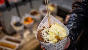 Eine Messebesucherin hält eine Tüte Pommes in der Hand
