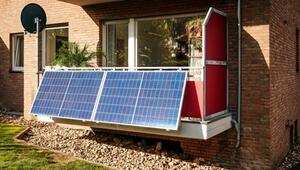Balkon mit zwei großen blauen Solarpaneelen, rotem Sichtschutz, Pflanzen und Satellitenschüssel ...