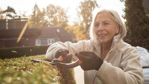 Eine Frau schneidet eine Hecke