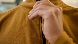 Ein Mann schließt den Reißverschluss einer Fleecejacke