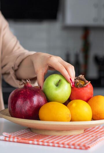 Person greift in Obstschale.