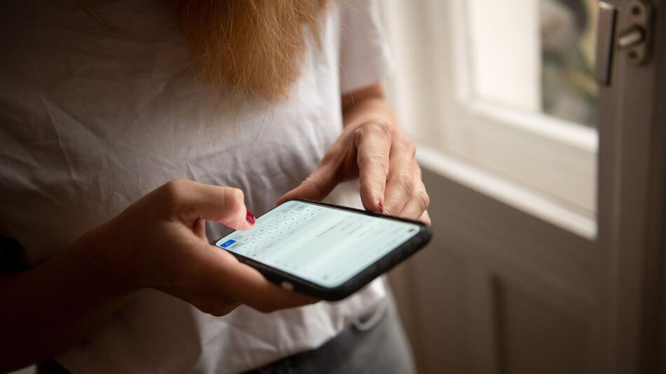 Eine Person tippt auf einem Smartphone