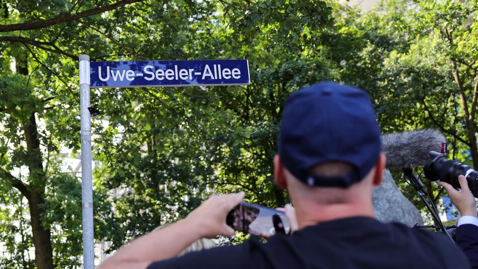 Fans fotografieren das Schild Uwe-Seeler-Allee vor dem HSV-Stadion