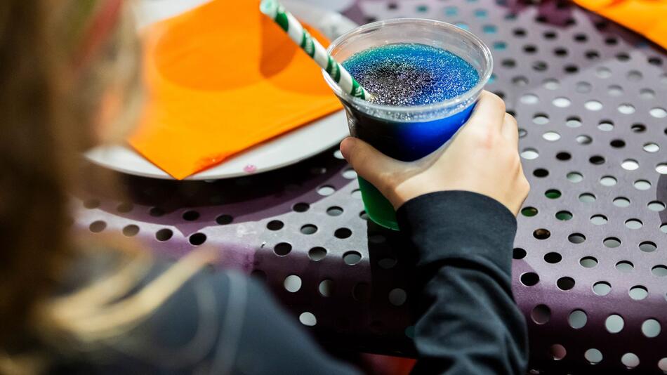 Kind trinkt ein Slush-Eis bei einem Kindergeburtstag